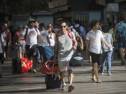 Turistas con maletas en La Rambla de Barcelona.