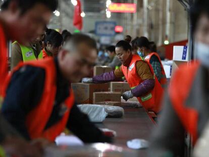 Trabajadores chinos clasifican pedidos de la empresa JD.com en Pekín con motivo del Día del soltero.