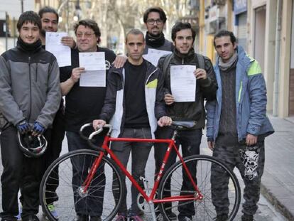 Repartidores de Deliveroo muestran la resolución de Trabajo junto al dirigente de Intersindical Valenciana, Marco Antonio Llerena (el tercero por la izquierda, con gafas), en Valencia.