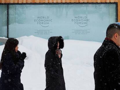 Varias personas pasan ante el centro de convenciones donde se celebra el Foro Económico en Davos.