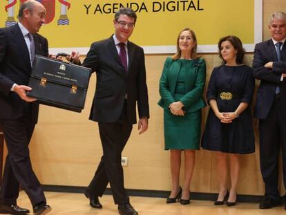 Álvaro Nadal recibe la cartera de manos de Luis de Guindos. En vídeo, declaraciones de Luis de Guindos.