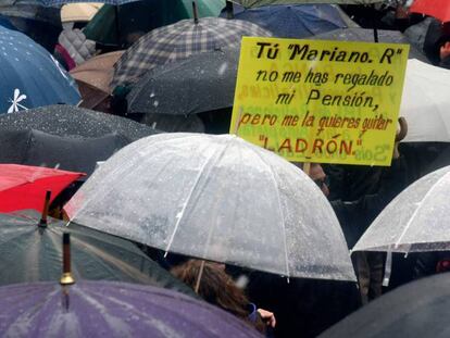 Manifestantes bajo la lluvia en la Puerta del Sol.