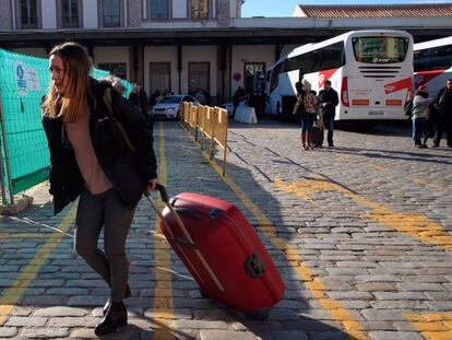 Una viajera baja del autocar que conecta con la estación de tren de Granada. / El recorrido de AVE más autobús desde Madrid a Granada.