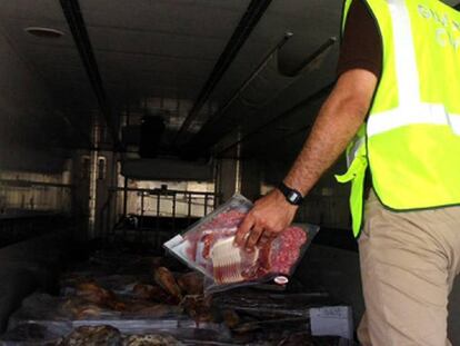 Un guardia civil en el interior del camión donde se encontraron miles de jamones caducados. En vídeo, imágenes de la intervención de la Guardia Civil, el pasado 9 de julio.