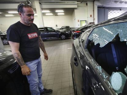 Un trabajador de Vector junto con un coche con la ventana rota. En vídeo, declaraciones de Eduardo Martín, presidente de Unauto VTC.