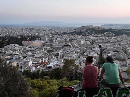 Dos jóvenes observan Atenas desde una colina, a comienzos de este mes. En vídeo, declaraciones del comisario europeo de Asuntos Económicos, Pierre Moscovici.