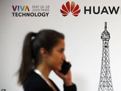 Una mujer pasa delante de un logo de Huawei, este domingo en París.
