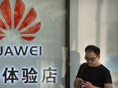 Un hombre frente a una tienda de Huawei este miércoles. En vídeo, declaraciones del jefe del Departamento Legal de Huawei.