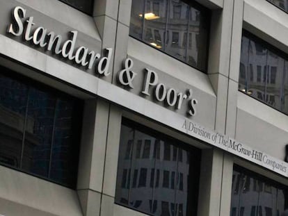 En foto, un hombre pasa delante de la sede de Standard & Poor's en Nueva York. En vídeo, Nadia Calviño habla sobre la calificación de S&P.