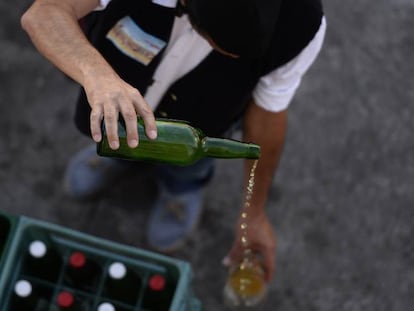 Un hombre escancia sidra en una feria en Gijón. En vídeo, Asturias pierde la exclusividad de la botella sidra.