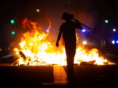 Un manifestante ante una hoguera en Barcelona el miércoles por la noche. En vídeo, rueda de prensa del ministro del Interior, Fernando Grande-Marlaska, sobre los disturbios acaecidos en Cataluña.