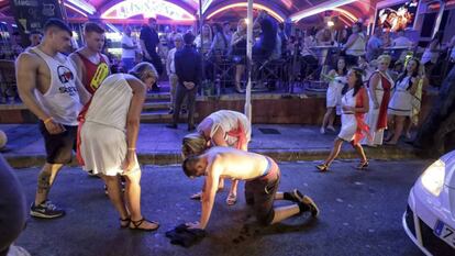 Un turista en estado de embriaguez se desploma en una calle de Magaluf. En vídeo, el Gobierno de Islas baleares aprueba una ley para la lucha total contra el turismo de borrachera.
