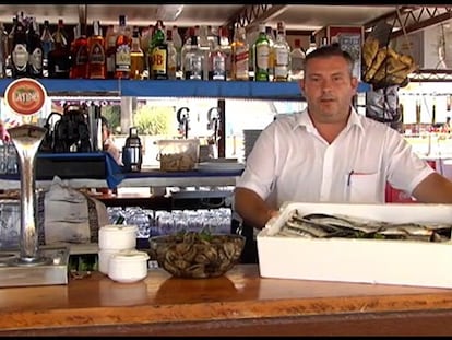Un camarero muestra el menú de la dieta del chiringuito en la barra.