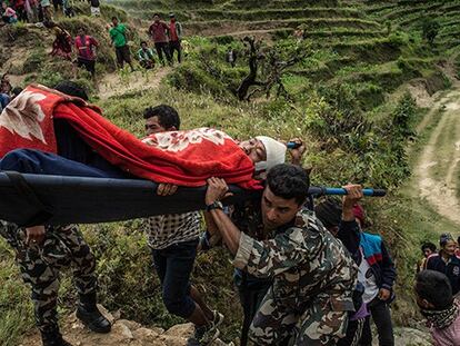 Una persona herida en Nepal es trasladada a un helicóptero.