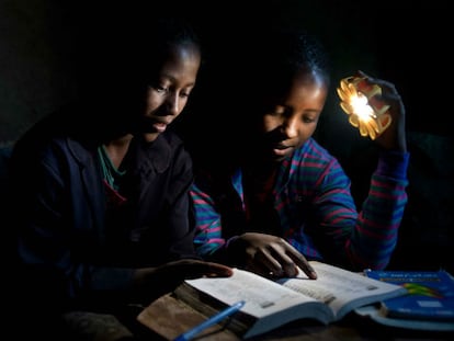 Dos niñas estudian alumbradas por la lámpara Little Sun.