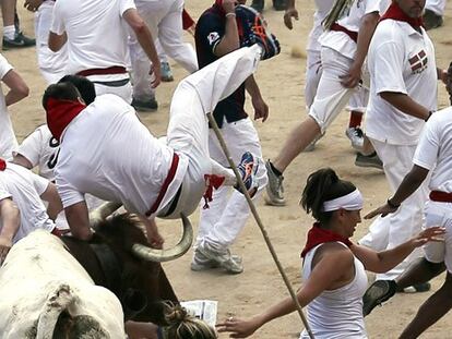 Un mozo es zarandeado por uno de los toros en la entrada de la plaza.