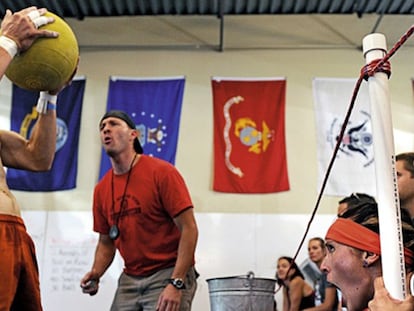 Deportista de crossfit, sosteniendo un balón medicinal.