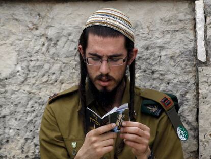 Um soldado israelense reza em um cemitério de Jerusalém.