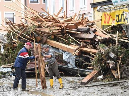 Dos hombres recogen restos arrastrados por las lluvias en la localidad alemana de Simbach am Inn este jueves.