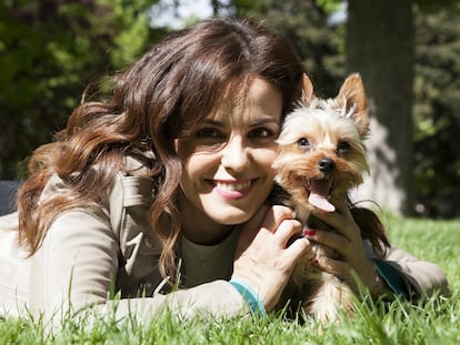 La actriz tumbada con su perro Rufus Júnior en el parque del Retiro, en Madrid,
