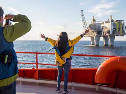 Dos cruceristas ante una plataforma petrolífera.