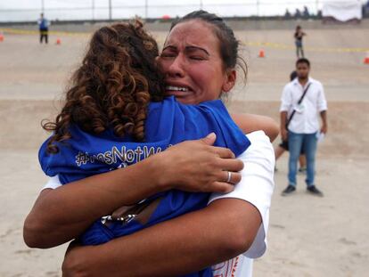 Una mujer abraza a una niña durante el evento 'Abrazos, no muros'.