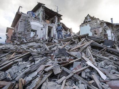 Los equipos de búsqueda y rescate trabajan entre los escombros de un edificio en Amatrice.