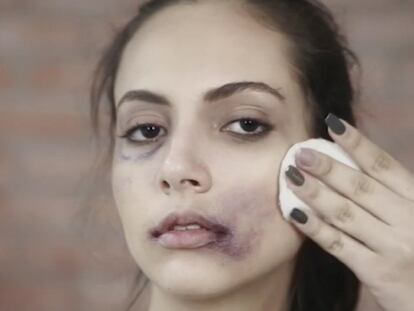 Una mujer con signos de maltrato se desmaquilla ante la cámara.