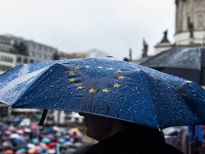 Un hombre sostiene un paraguas con la bandera de la UE