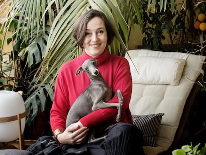 La agente literaria Mónica Martín y su perra, Greta, en su casa de Barcelona. Abajo,
la galga italiana en su capazo.