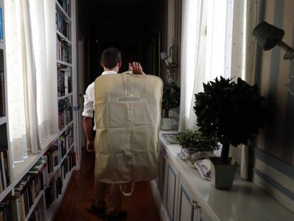 Un asistente personal de la empresa Ambrosio lleva un traje del tinte a la casa del cliente.