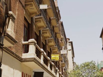 Una calle del barrio de Chueca en Madrid con carteles de alquileres de habitaciones.