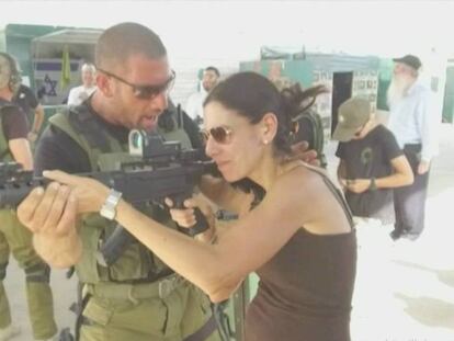 Uno de los militares del campamento enseñando a una turista norteamericana a disparar.