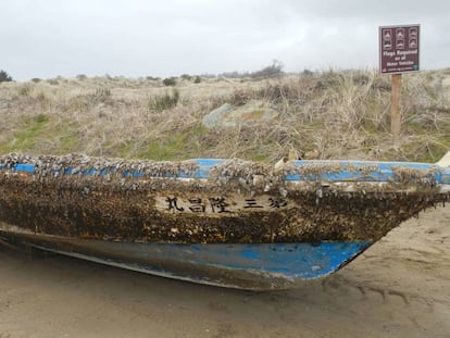 Esquife japonés infestado de percebes varado en una playa de Oregón.