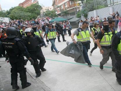 Agentes de la policía nacional retiran urnas de un colegio electoral de Tarragona.