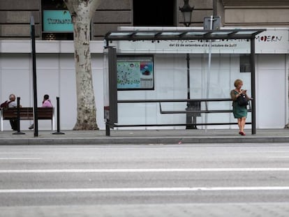 Una mujer espera al autobús en Barcelona.