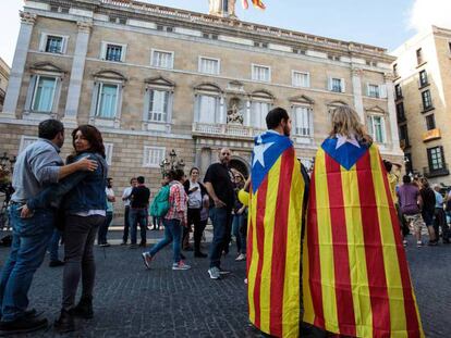 Dos personas con la bandera independentista, este sábado frente al Palau de la Generalitat.