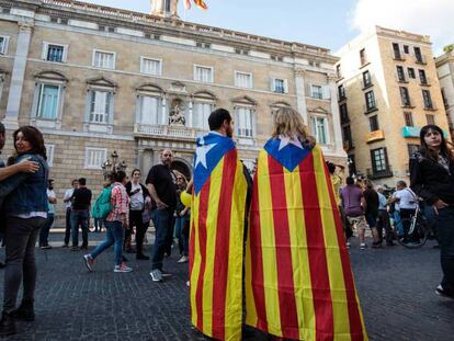 Dos personas con la bandera independentista, este sábado frente al Palau de la Generalitat.