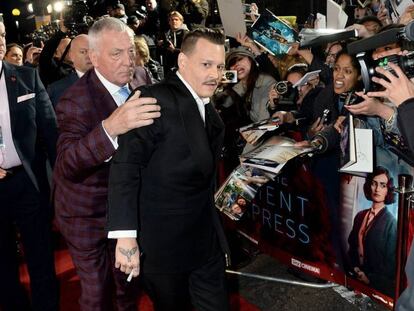 Johnny Depp en el estreno en Londres de 'Asesinato en el Orient Express', sujetado por su guardia de seguridad privado.