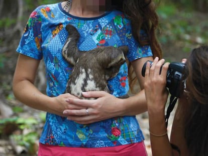 Una turista se hace fotos con un perezoso.