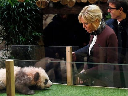 La primera dama de Francia saluda junto a niños vestidos de panda este lunes.