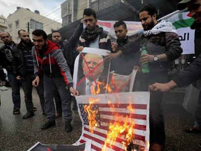 Varios palestinos queman banderas de EE UU y fotos de Trump.