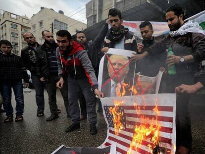Varios palestinos queman banderas de EE UU y fotos de Trump.