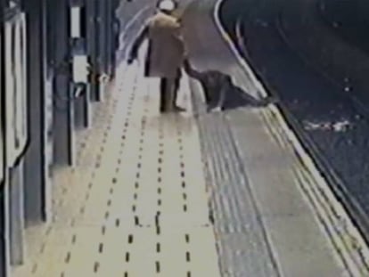 Un pasajero ayuda a otro a subir de las vías del tren en Reino Unido.