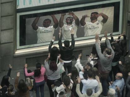 Los viandantes hacen la ola junto a los jugadores del Real Madrid en la Gran Vía.
