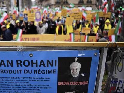 Los manifestantes sostienen pancartas con un retrato del presidente iraní Hassan Rouhani.