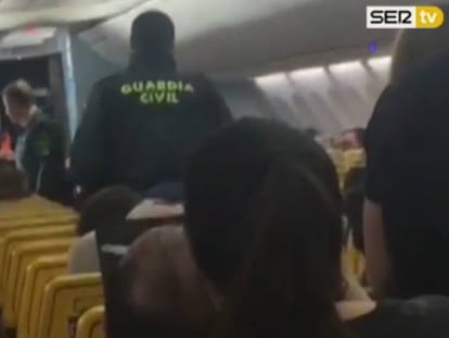 Fotograma del momento en el que un agente habla con una pareja "conflictiva" en un avión.