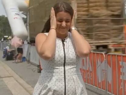 Una presentadora de televisión, mientras un cambió arrastra la meta de una carrera ciclista en Australia.