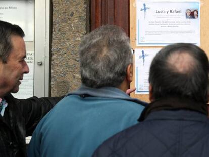 Vecinos de los fallecidos observan la esquela de los dos ancianos muertos.