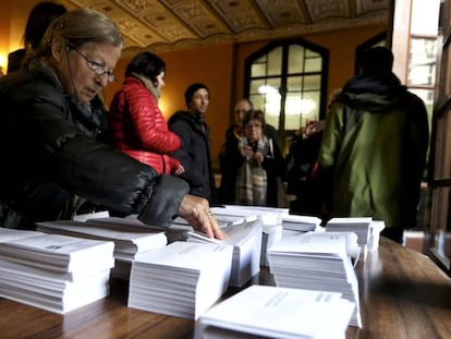 Una mujer elige una papeleta para votar en las elecciones autonómicas de Cataluña.